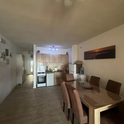a kitchen with a wooden table and chairs and a dining room at Apartman Aleksandar in Ulcinj
