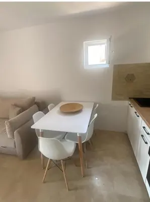 a small kitchen with a white table and chairs at Apartment Talas in Budva