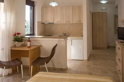 a kitchen with a table and two chairs and a table at Apartments Lumiere in Rafailovici