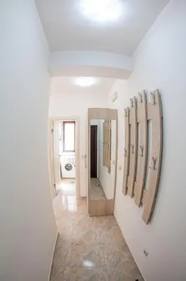 a hallway with mirrors on the walls of a bathroom at Apartments Lumiere in Rafailovici