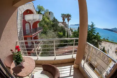 a balcony with a table and chairs and the ocean at Apartments Lumiere in Rafailovici