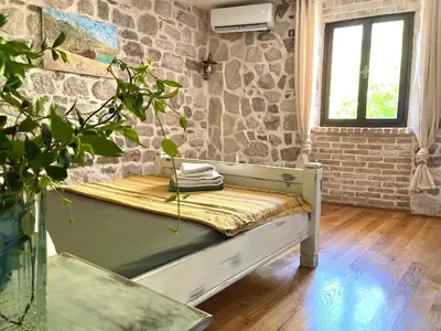 a room with a bench and a stone wall at Una apartments in Kotor