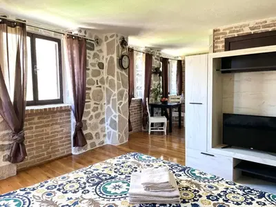 a living room with a flat screen tv and a fireplace at Una apartments in Kotor