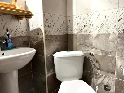 a bathroom with a white toilet and a sink at Una apartments in Kotor