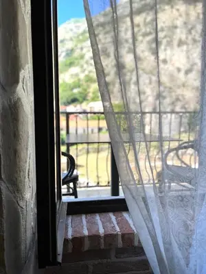 an open window with a view of a bench on a porch at Una apartments in Kotor