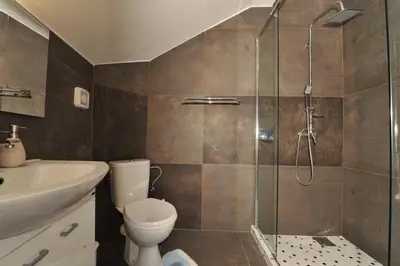 a bathroom with a shower and a toilet and a sink at Una apartments in Kotor