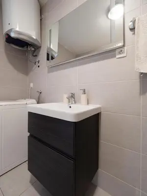a bathroom with a sink and a mirror at Family Three bedroom Apartment Brando in Budva