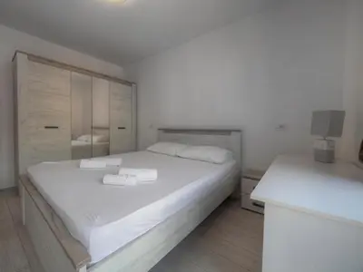 a bedroom with a large white bed with two towels at Family Three bedroom Apartment Brando in Budva