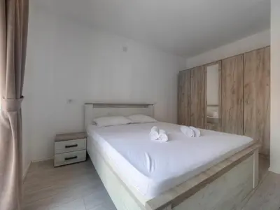 a bedroom with a white bed with two white towels at Family Three bedroom Apartment Brando in Budva