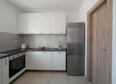 a kitchen with white cabinets and a stainless steel refrigerator at Family Three bedroom Apartment Brando in Budva