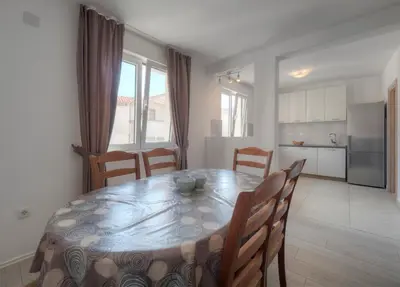 a kitchen and dining room with a table and chairs at Family Three bedroom Apartment Brando in Budva