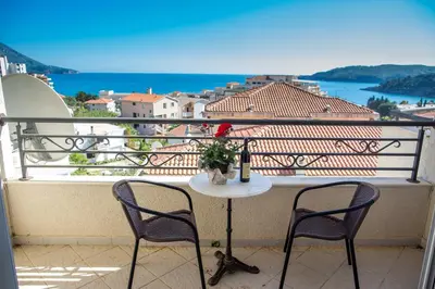 a table with a vase of flowers on a balcony at Apartments Charme in Becici