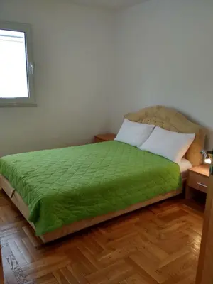 a bedroom with a bed with a green comforter at Apartments Charme in Becici