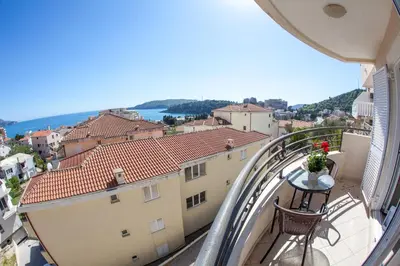 a balcony with a table and a view of a city at Apartments Charme in Becici