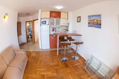 a living room with a couch and a kitchen at Apartments Charme in Becici