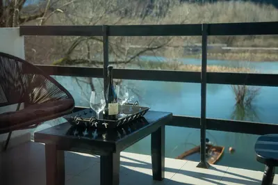 a table with wine glasses on top of a balcony at Lux Apartment Sunset in Virpazar