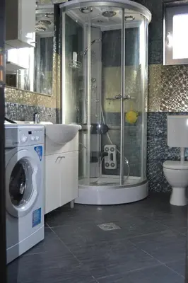 a bathroom with a shower and a washing machine at Old Town View Apartment in Budva