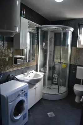 a bathroom with a shower and a sink and a washing machine at Old Town View Apartment in Budva