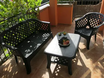 two chairs and a table with a bowl of fruit on it at Apartments Victoriya in Sutomore