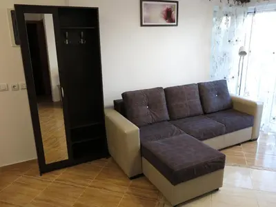 a living room with a couch and a mirror at Apartments Victoriya in Sutomore