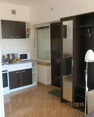 a kitchen with black and white cabinets and a microwave at Apartments Victoriya in Sutomore