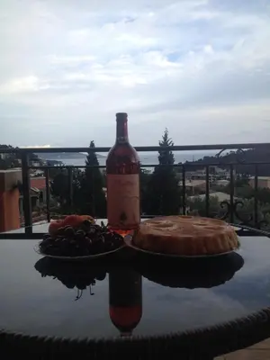 a bottle of wine and a pie on a table at Apartments Victoriya in Sutomore