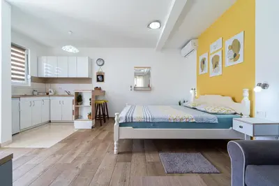 a small bedroom with a bed and a kitchen at Apartments Gruda in Cetinje