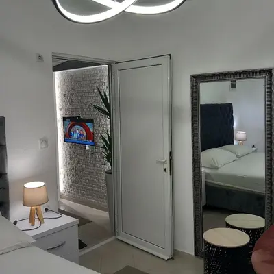 a bedroom with a door leading to a bed and a mirror at Apartments Doha in Ulcinj