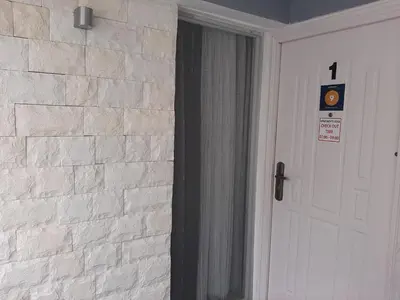 a white brick wall next to a white door at Apartments Doha in Ulcinj