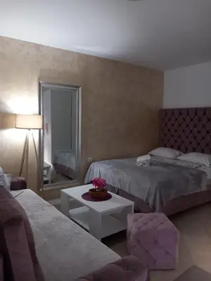 a hotel room with two beds and a table at Apartments Doha in Ulcinj
