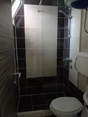 a bathroom with a toilet and a glass shower at Apartments Doha in Ulcinj