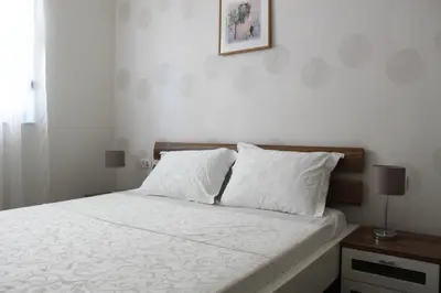 a bedroom with a white bed with two pillows at Apartment Golubović Kotor in Kotor