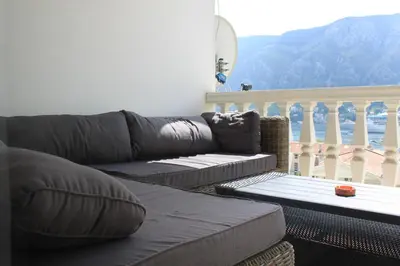 a living room with a couch and a balcony at Apartment Golubović Kotor in Kotor