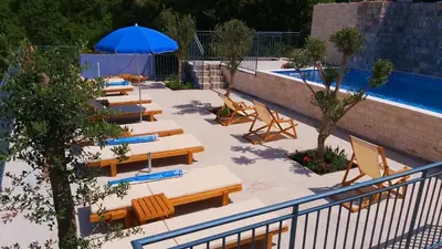 a group of tables and chairs next to a swimming pool at Blue Mediterranean Apartments in Sveti Stefan