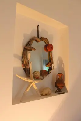 a wreath hanging on a wall with a mirror at Blue Mediterranean Apartments in Sveti Stefan
