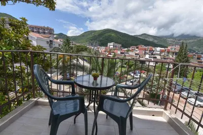 a table and chairs on a balcony with a view of a city at Studio Apartments 6 Palmi in Budva
