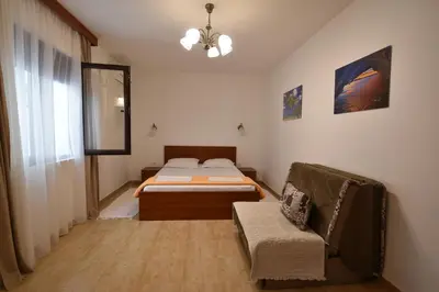 a bedroom with a bed and a couch in it at Studio Apartments 6 Palmi in Budva