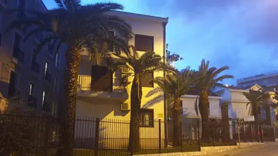 a building with palm trees in front of it at Studio Apartments 6 Palmi in Budva