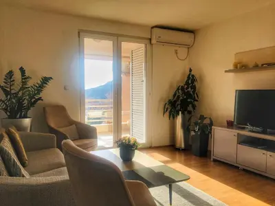 a living room with a couch and a table and a television at Home Apartment Petrovac in Petrovac na Moru
