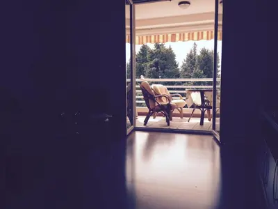 a room with a balcony with a chair on a porch at Home Apartment Petrovac in Petrovac na Moru