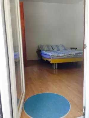a room with a bed and a blue rug at Home Apartment Petrovac in Petrovac na Moru