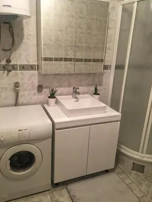 a bathroom with a sink and a washing machine at Home Apartment Petrovac in Petrovac na Moru