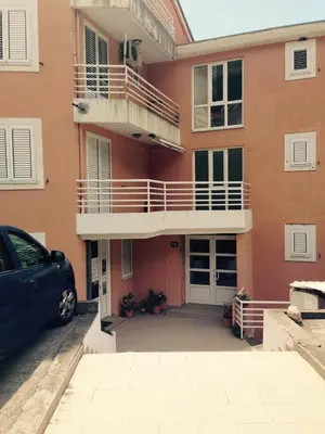 a car parked in front of a building with a balcony at Home Apartment Petrovac in Petrovac na Moru