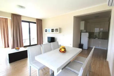 a kitchen and dining room with a white table and chairs at Apartments Aqua in Budva