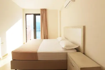 a bedroom with a large bed with a window at Apartments Aqua in Budva