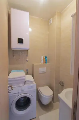a bathroom with a washing machine and a toilet at Apartments Aqua in Budva