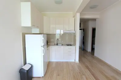 a kitchen with white cabinets and a white refrigerator at Apartments Aqua in Budva