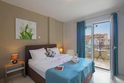 a bedroom with a bed with a blue blanket at Le Marc Guest house in Budva