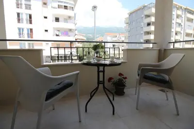 a balcony with a table and two chairs and a window at Le Marc Guest house in Budva