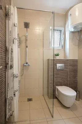 a bathroom with a toilet and a glass shower at Le Marc Guest house in Budva